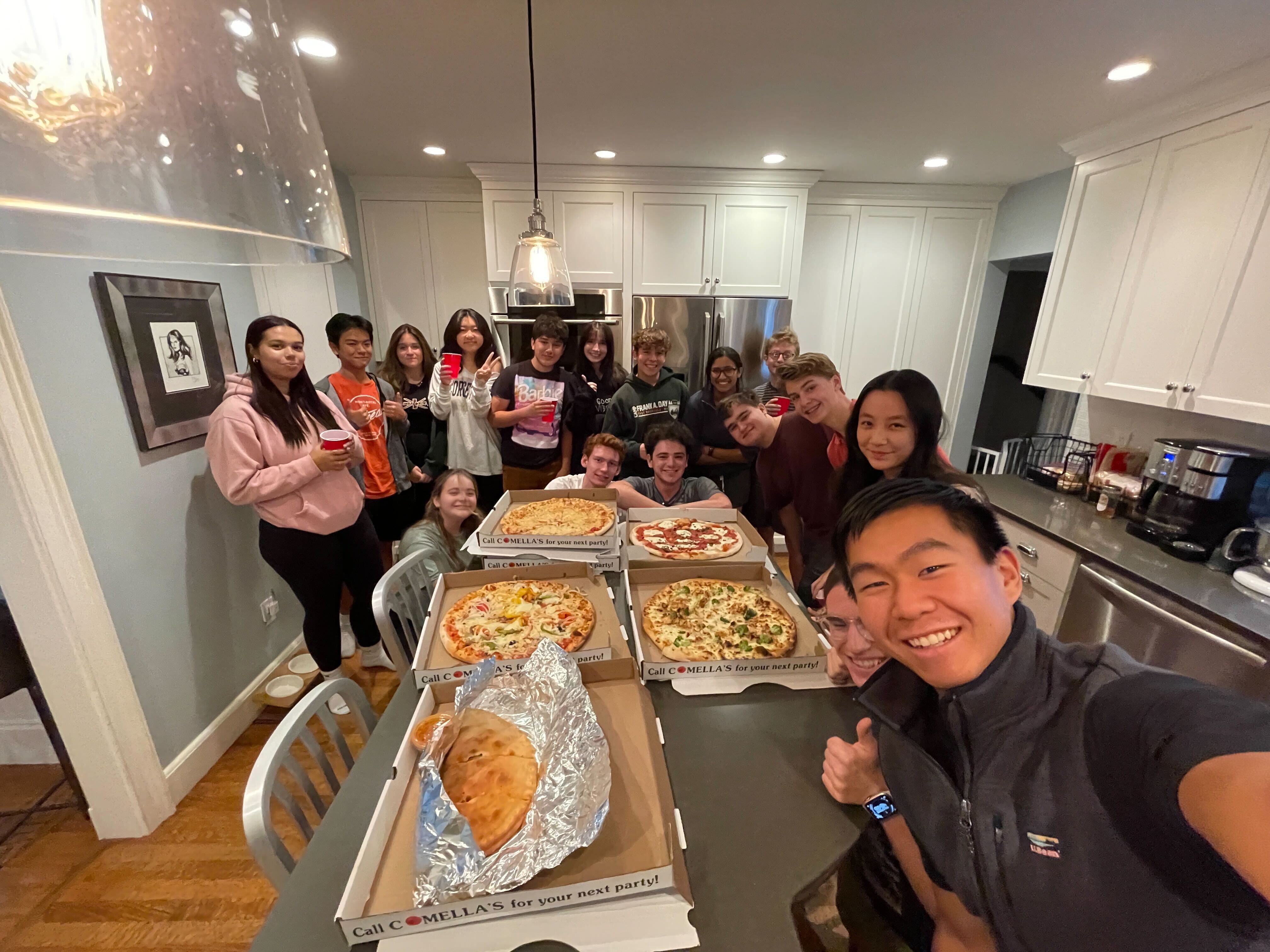 Group of teenage hackers enjoying GitHub Hack Club Pizza Grant